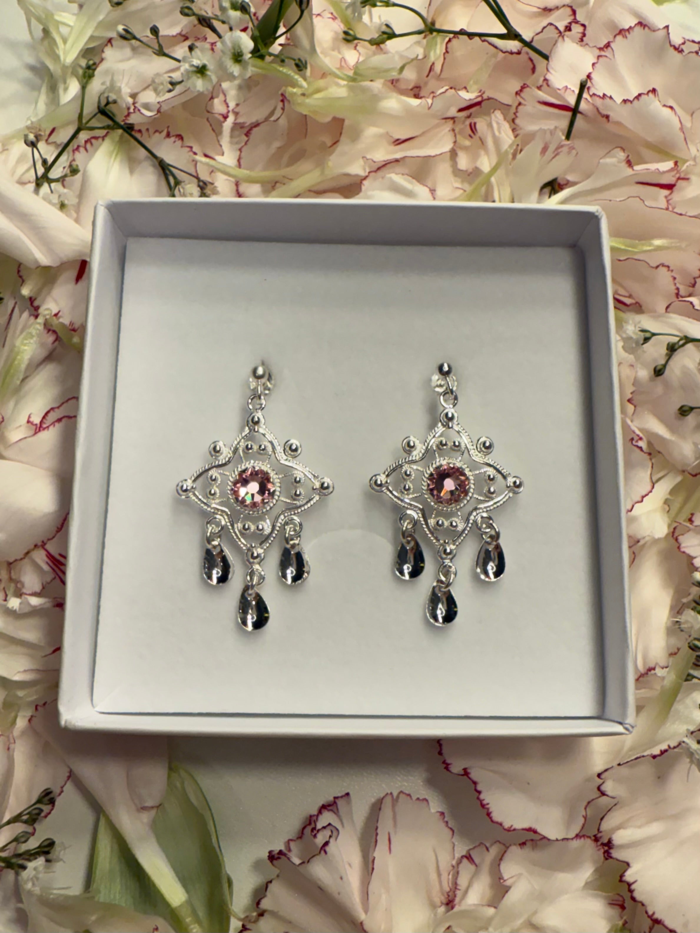 Ørepynt med lyserosa krystall