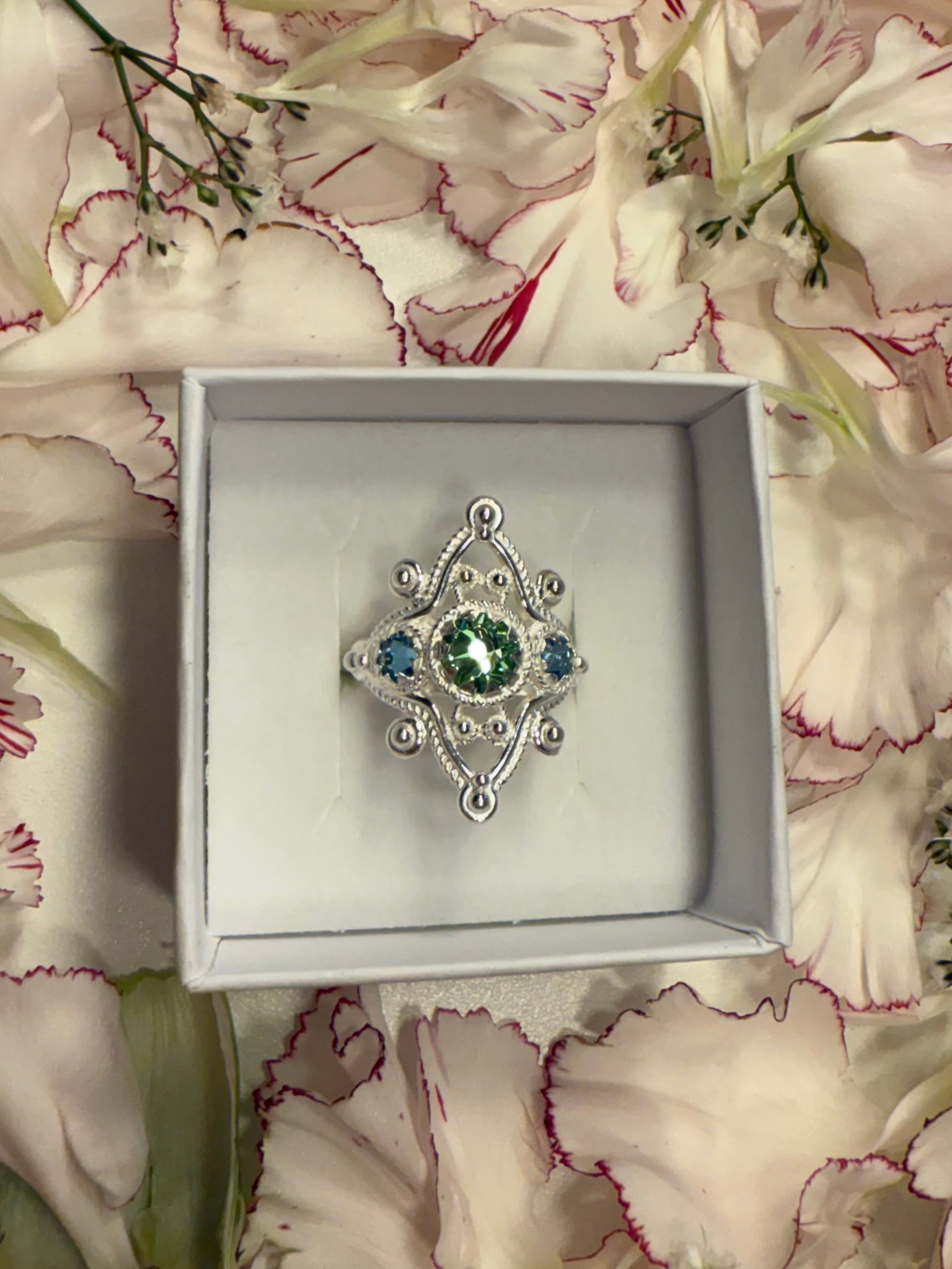 Ring med lyseblå og grønn krystall