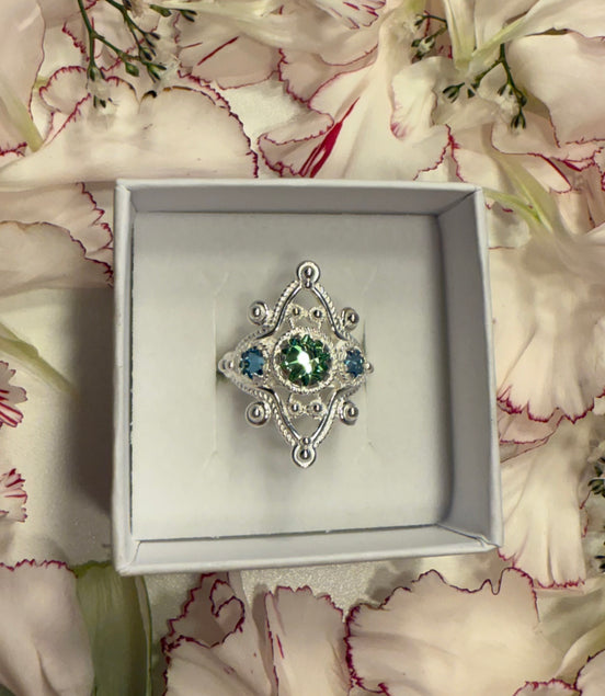 Ring med lyseblå og grønn krystall