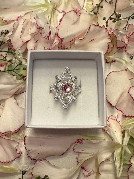 Ring med nordlys og lyserosa krystall